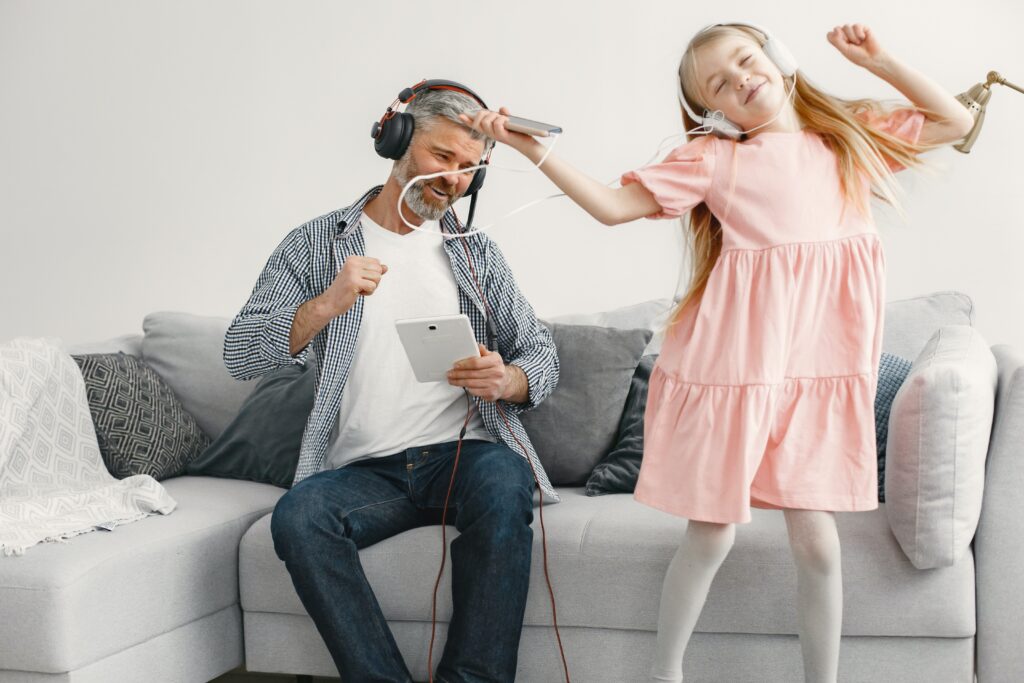 father And Daughter Listening To Music Daughter Is Dancing And Looking Happy. 