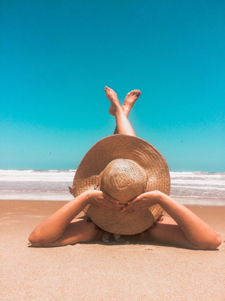 Woman Lying On Beach On A Sunny Dat By The Sea