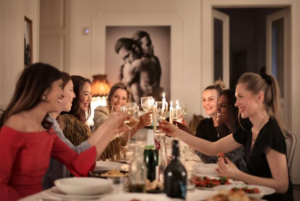 Group Of People Toasting At Dinner Party