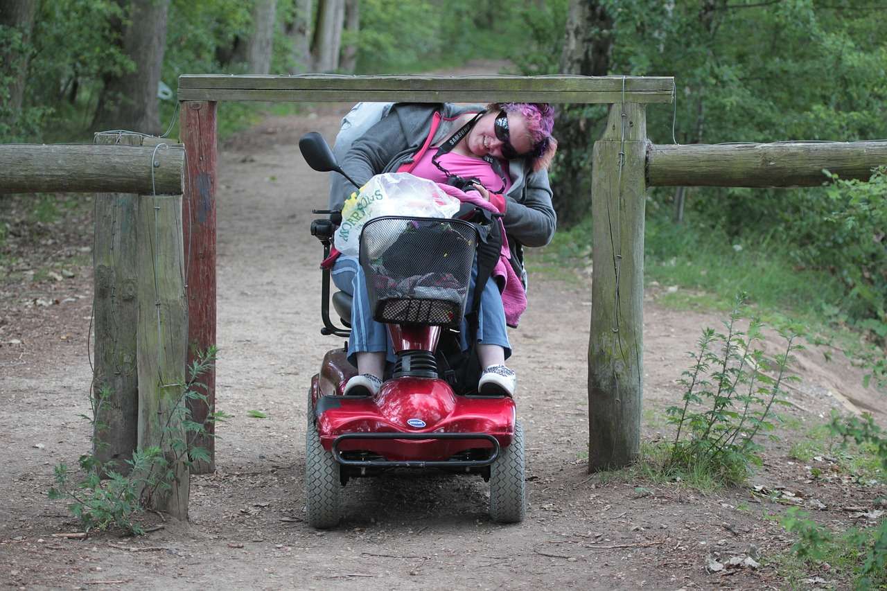 Woman Riding Mobility Scooter In Countryside