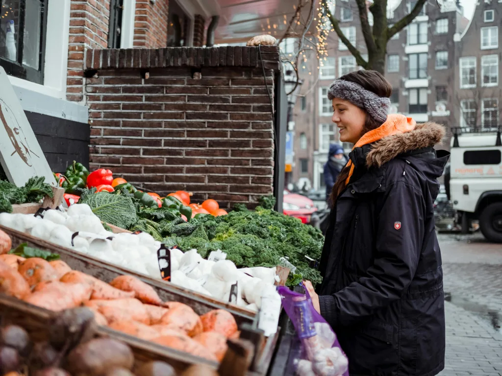 Young Woman At Vegetable Market Stall